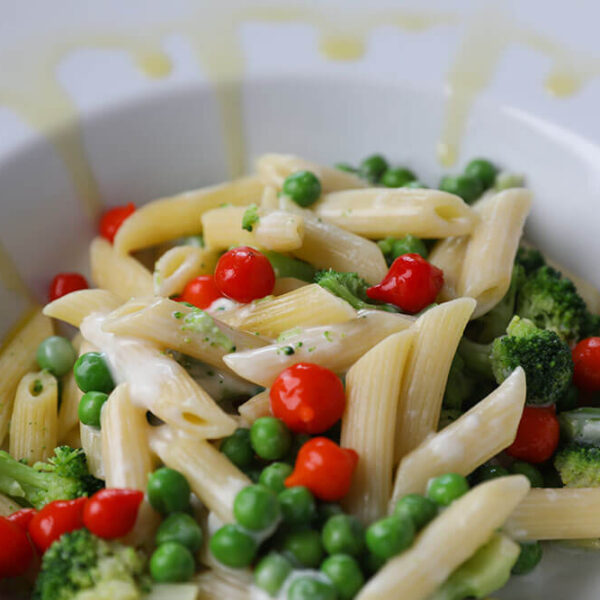 Penne Pasta with Peas, Broccoli and Lily Peppers® drizzled with oil