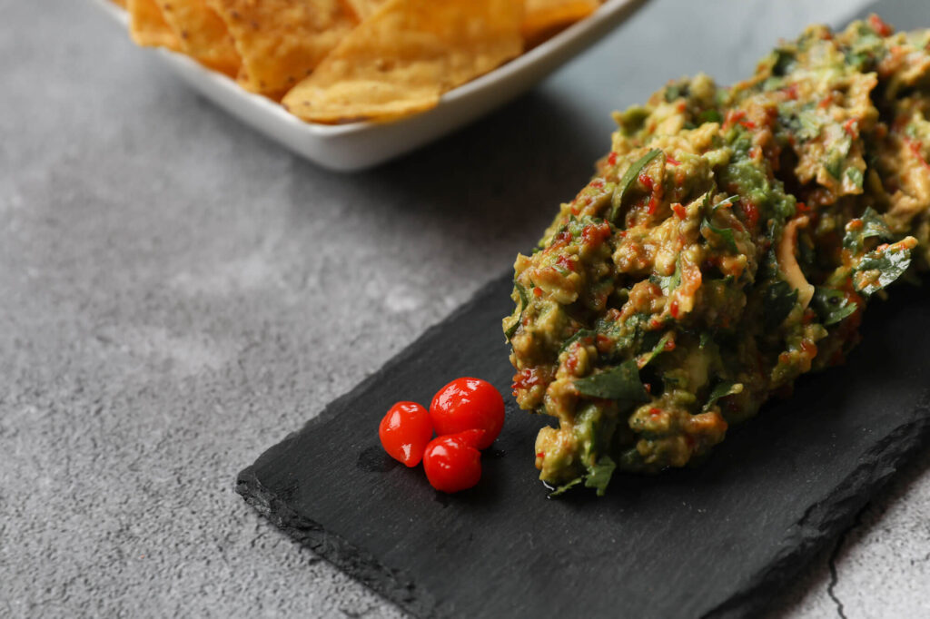 TIGER LILY PEPPER & LIME SAMBAL GUACAMOLE closeup with peppers